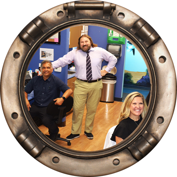 A group of people in a room with a porthole.